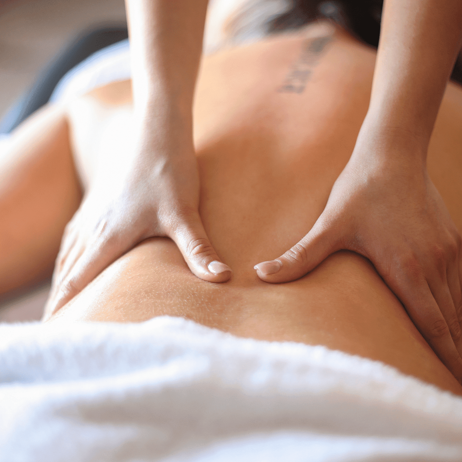 Person receiving a back massage with professional hands focusing on relaxation and therapy.